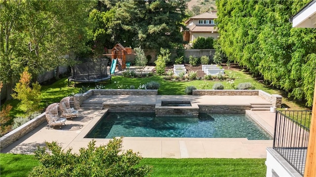 view of swimming pool with an in ground hot tub, a yard, a patio, and a trampoline