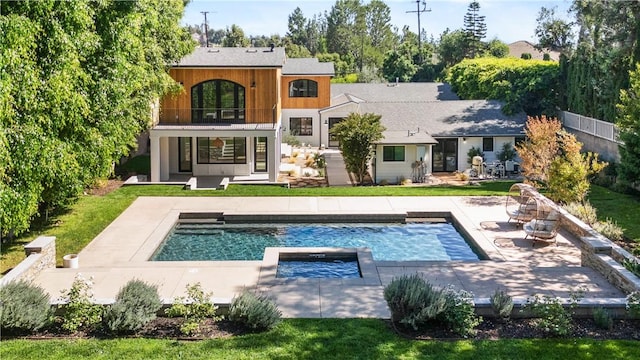 back of house featuring a patio area, a balcony, and a pool with hot tub