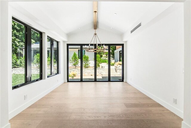 unfurnished room featuring vaulted ceiling with beams, light wood-type flooring, and an inviting chandelier