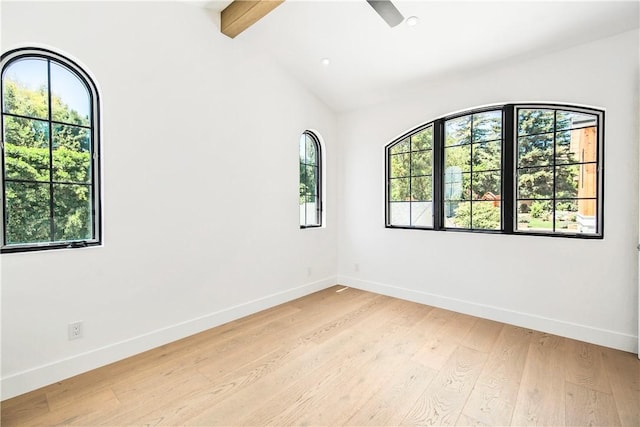 unfurnished room with light wood-type flooring, lofted ceiling with beams, and plenty of natural light