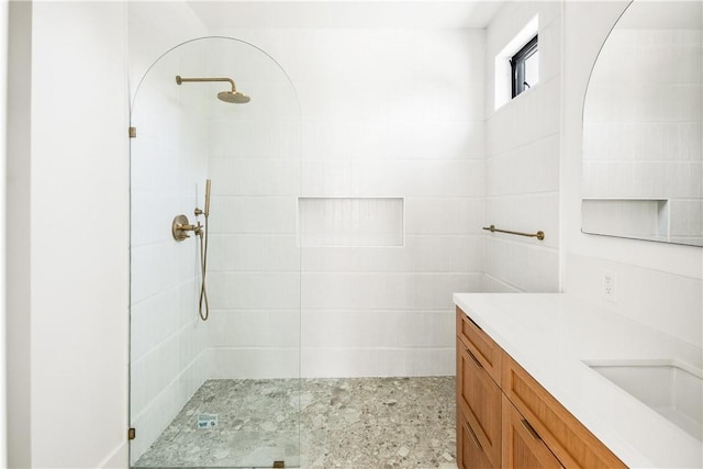 bathroom with vanity and tiled shower