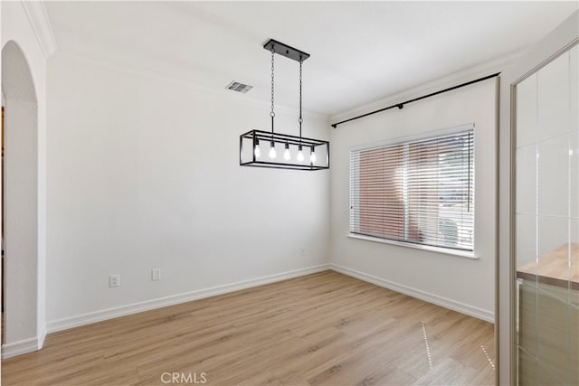 unfurnished dining area featuring light wood-type flooring and ornamental molding