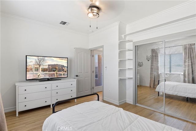 bedroom with ceiling fan, a closet, light hardwood / wood-style flooring, and ornamental molding