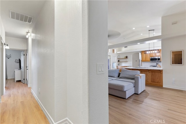 corridor with light hardwood / wood-style floors