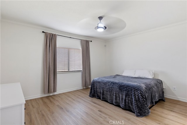 bedroom with light hardwood / wood-style floors, ceiling fan, and crown molding