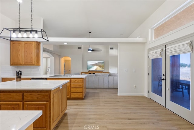 kitchen featuring pendant lighting, light hardwood / wood-style floors, tasteful backsplash, high vaulted ceiling, and french doors