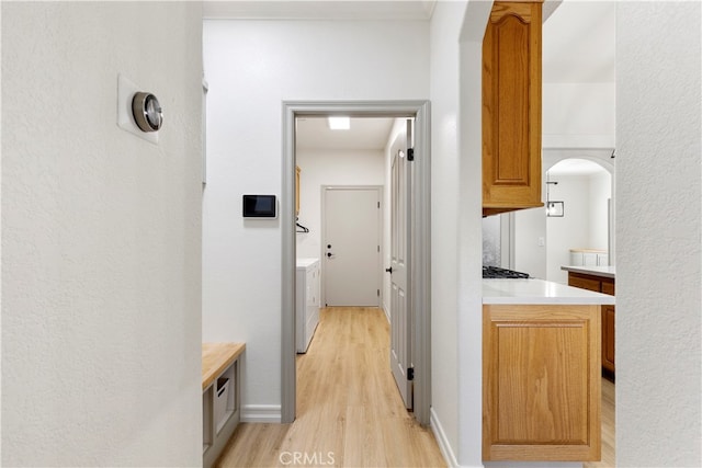 corridor with light wood-type flooring and washer / clothes dryer