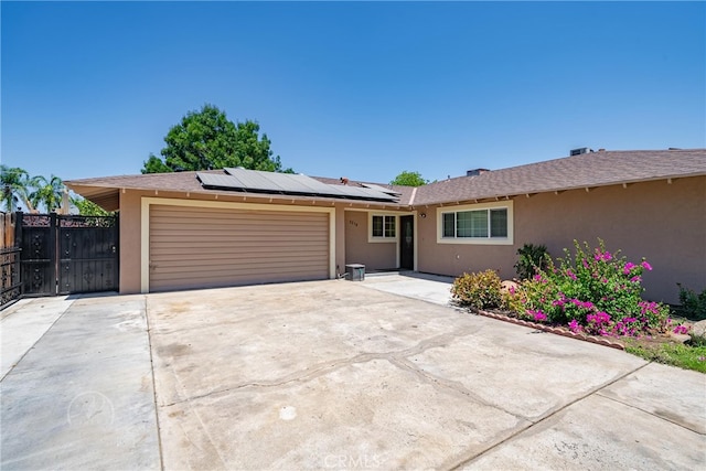 ranch-style home with solar panels and a garage