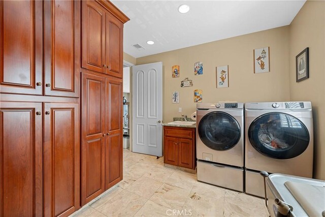 washroom featuring cabinets, washer and dryer, and sink