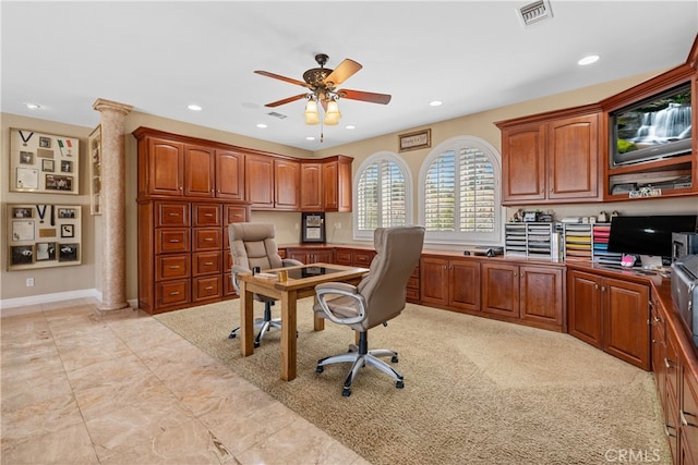 office area with built in desk, ornate columns, and ceiling fan