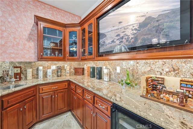 kitchen featuring light stone countertops, sink, and beverage cooler