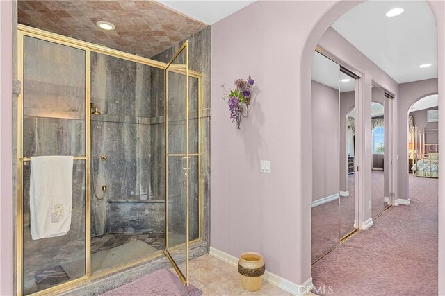 bathroom with a shower with shower door and tile patterned flooring