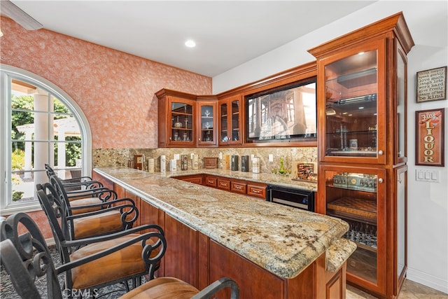 bar with light tile patterned floors, light stone countertops, beverage cooler, and tasteful backsplash