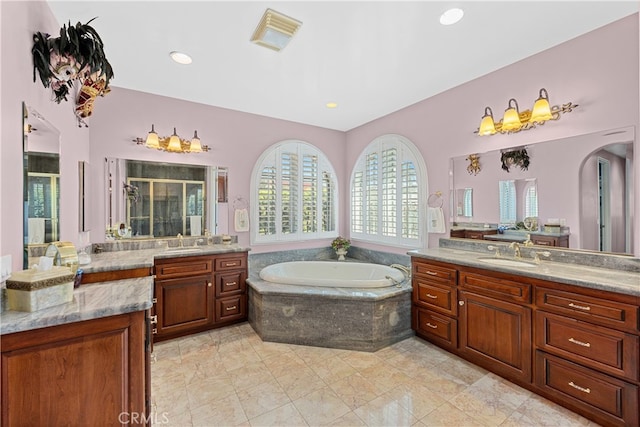 bathroom with vanity and shower with separate bathtub