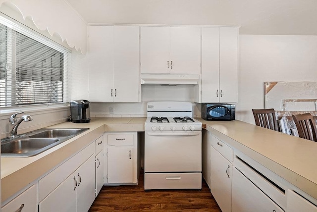 kitchen with white gas stove, white cabinets, dark wood-type flooring, and sink