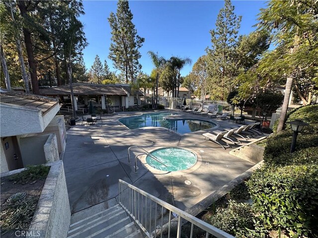 view of pool featuring a patio and a hot tub