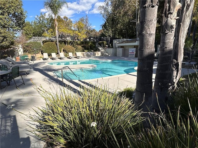 community pool with fence and a patio