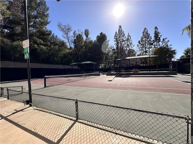 view of tennis court featuring fence