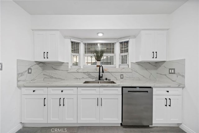 kitchen featuring stainless steel dishwasher, white cabinets, and sink