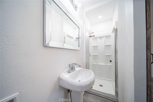 bathroom with a shower, sink, and hardwood / wood-style floors