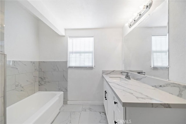 bathroom with a bath, plenty of natural light, and vanity