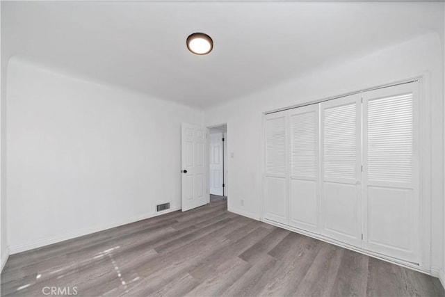 unfurnished bedroom with light wood-type flooring and a closet