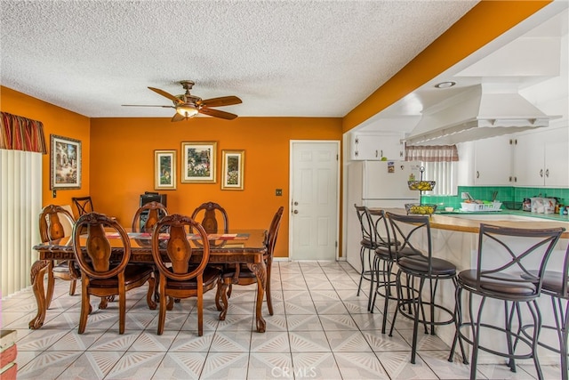 dining room featuring ceiling fan and a textured ceiling