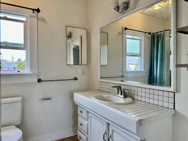 bathroom featuring a shower with shower curtain, decorative backsplash, toilet, and vanity