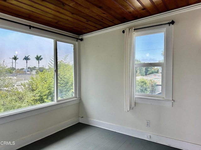 empty room featuring wood ceiling, a healthy amount of sunlight, and ornamental molding