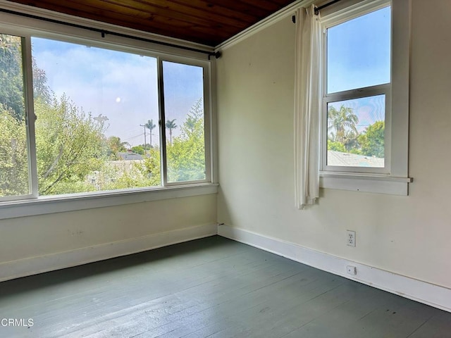 empty room featuring a wealth of natural light, crown molding, and wood ceiling