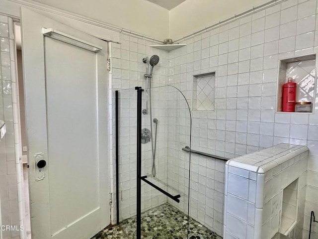 bathroom featuring a tile shower and tile walls