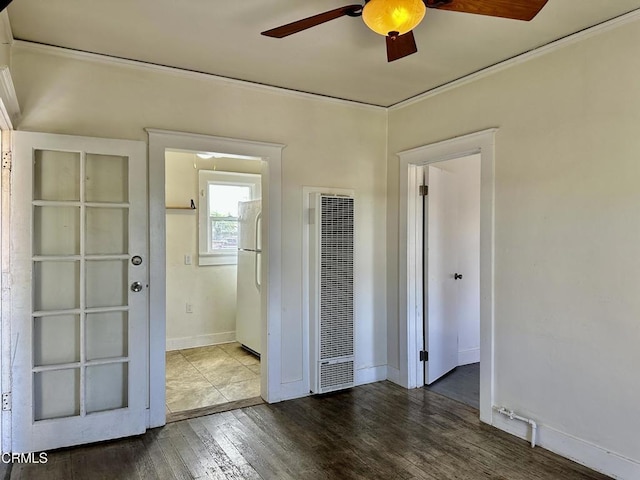 unfurnished room with ceiling fan, dark hardwood / wood-style flooring, and ornamental molding