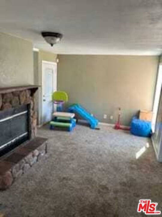 playroom featuring carpet floors and a fireplace