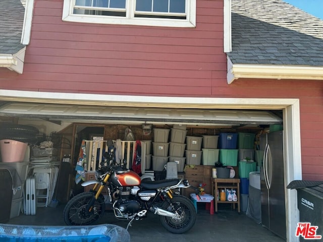 garage with wooden walls and stainless steel refrigerator