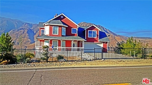 view of front of home featuring a garage, a mountain view, and covered porch