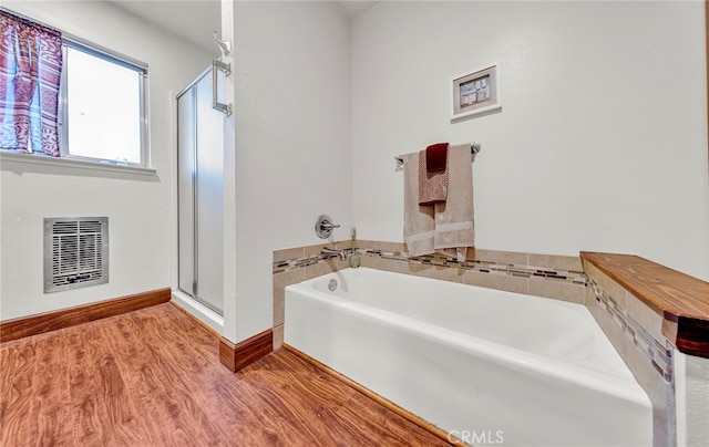 bathroom with independent shower and bath and hardwood / wood-style floors