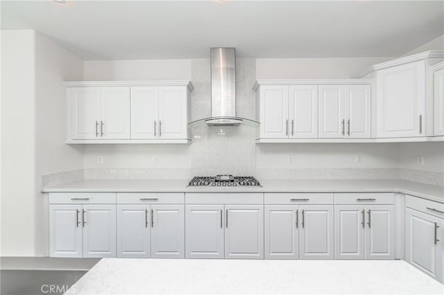 kitchen with white cabinets, stainless steel gas stovetop, and wall chimney range hood