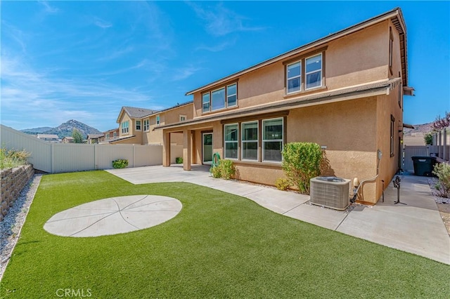 back of house featuring a patio area, a mountain view, a yard, and cooling unit