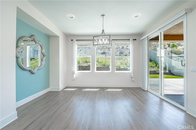 interior space with hardwood / wood-style flooring, a healthy amount of sunlight, and a chandelier