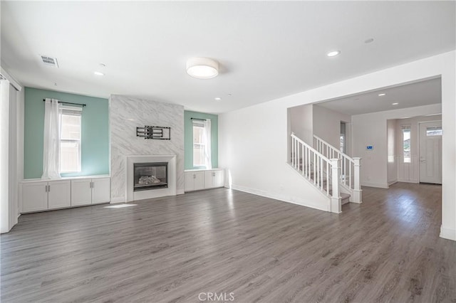 unfurnished living room with dark hardwood / wood-style floors and a premium fireplace