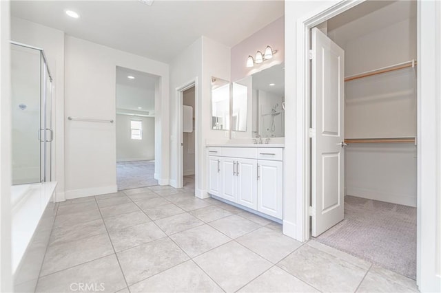 bathroom featuring tile patterned floors, vanity, and a shower with door