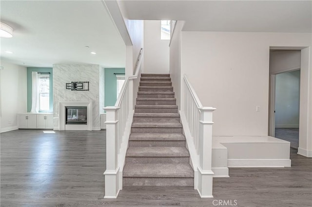 staircase featuring a fireplace and hardwood / wood-style floors