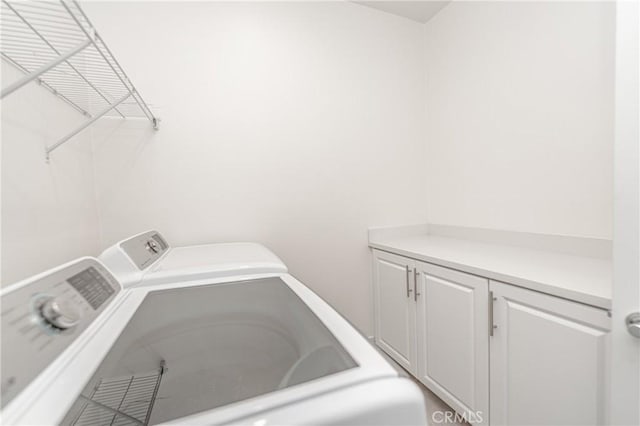 laundry area featuring cabinets and washer and clothes dryer