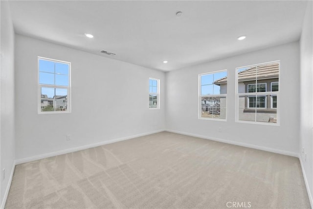 unfurnished room with plenty of natural light and light colored carpet