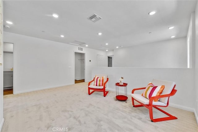 sitting room featuring light colored carpet