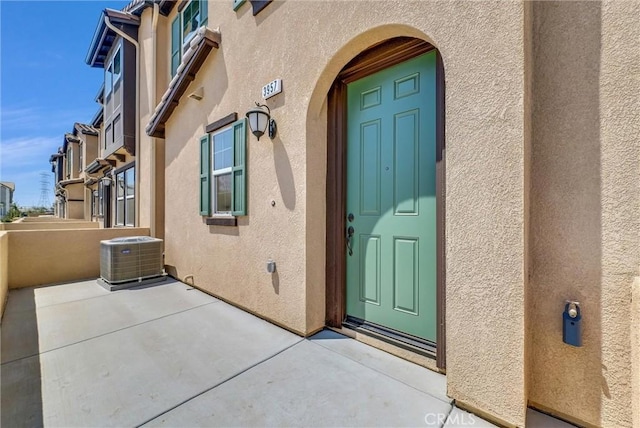 property entrance featuring a patio area and cooling unit