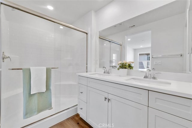 bathroom featuring hardwood / wood-style floors, vanity, and an enclosed shower