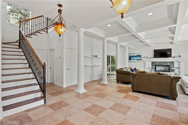 living room with a tile fireplace, ornate columns, and a wealth of natural light