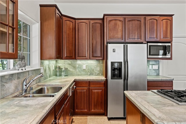 kitchen featuring stainless steel appliances, plenty of natural light, sink, and tasteful backsplash