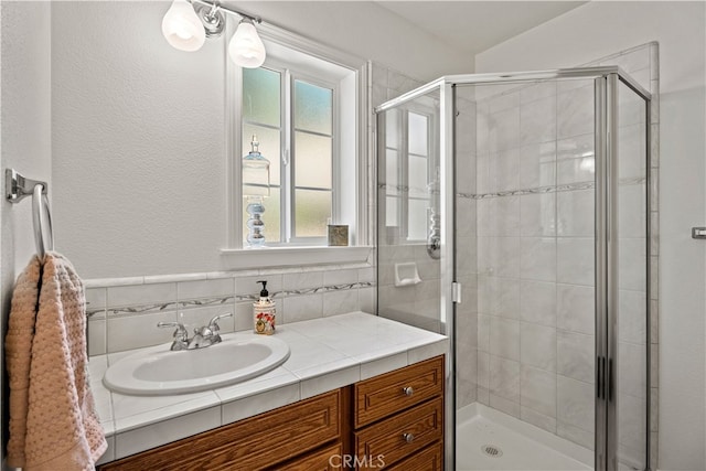 bathroom featuring vanity and a shower with door